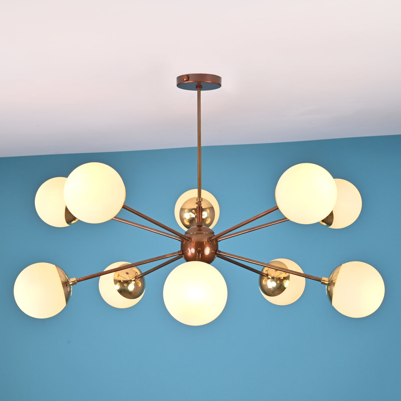Front elevation of a 10 light brass globe chandelier featuring a central sphere and balanced mid century modern design.