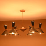 Side angle of illuminated 12-light brass and black cone chandelier with brushed brass arms and warm diffused lighting.