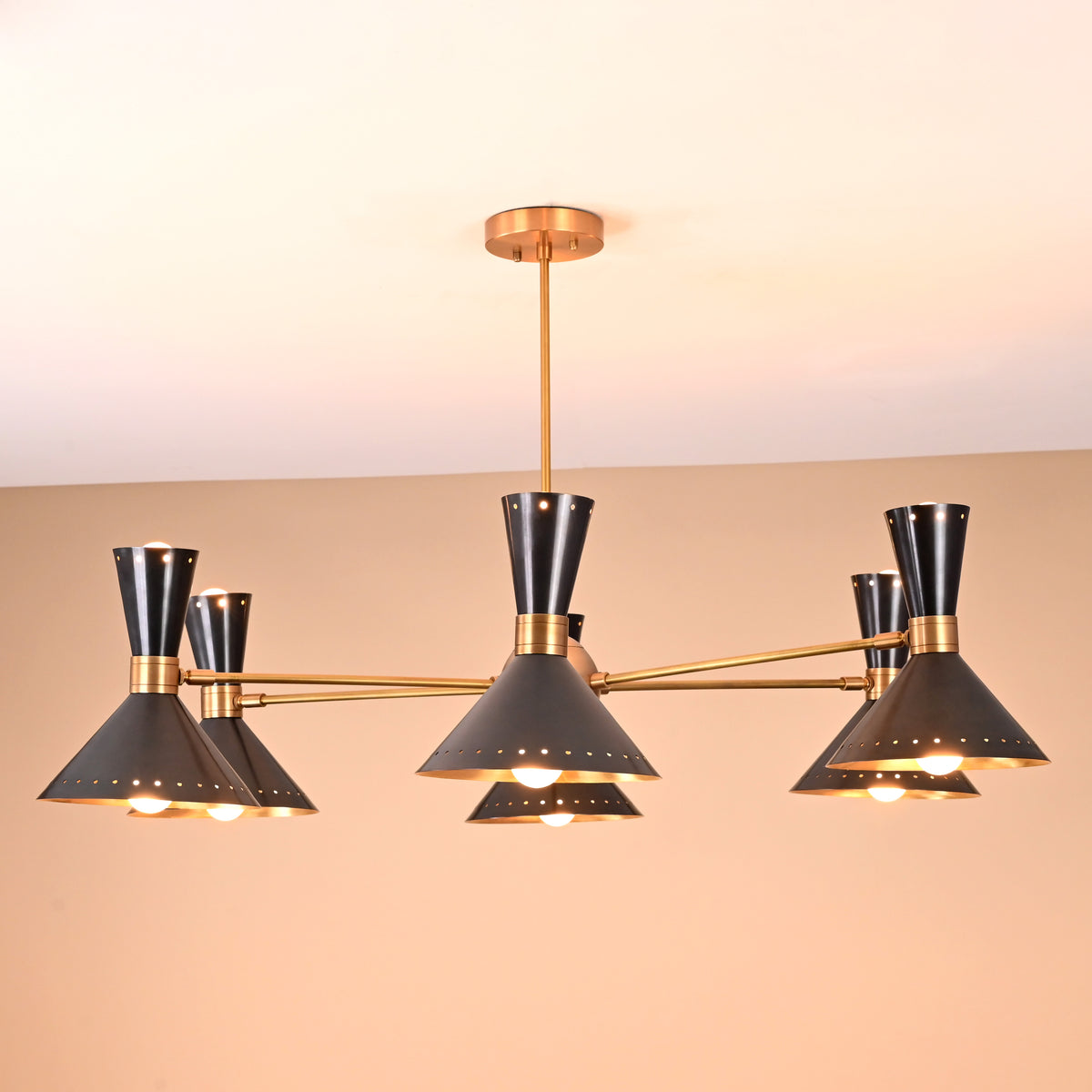 Side view of modern 12-light brass and black cone chandelier featuring dual-cone shades and mid-century design by Brass Leaf Studio.