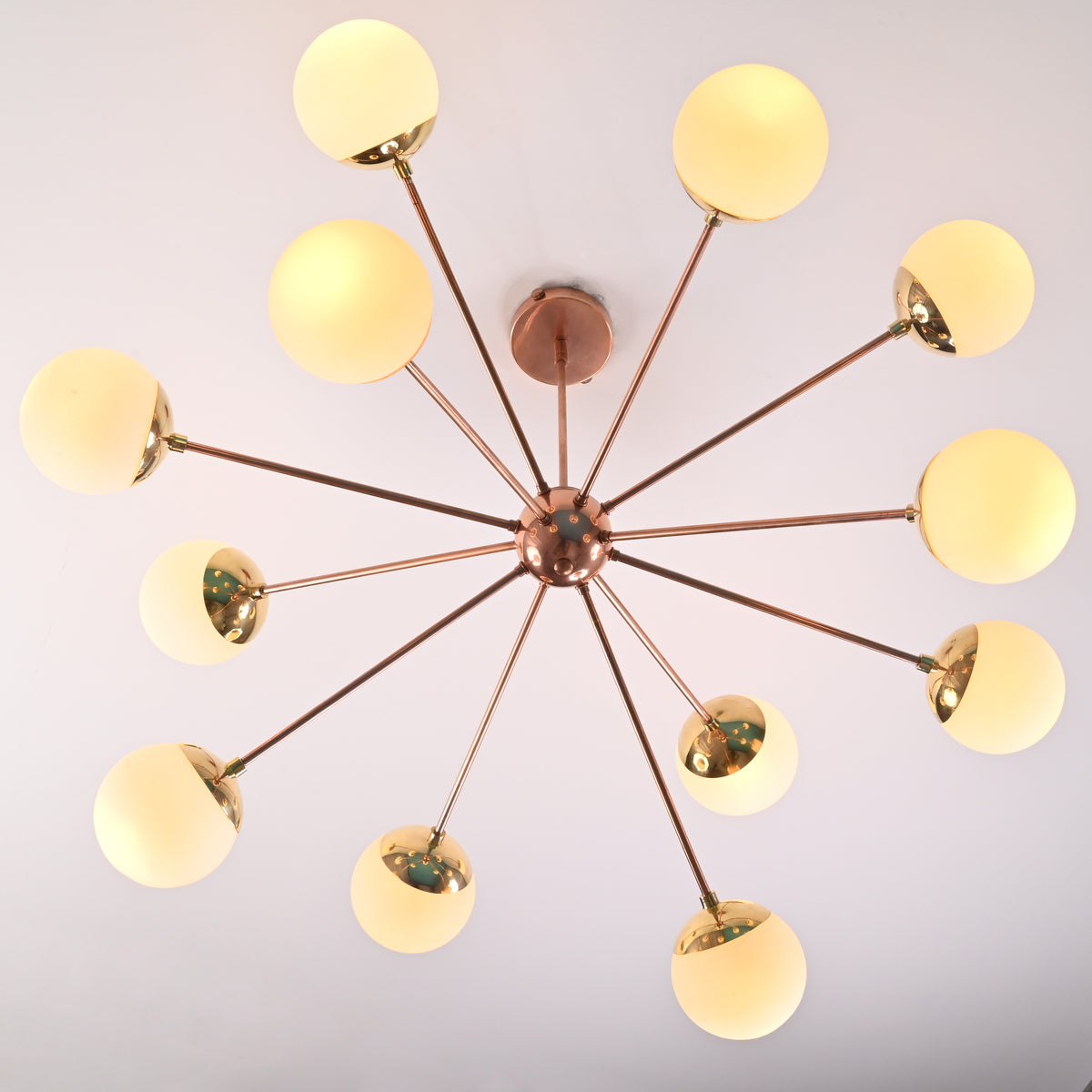 Bottom view of 12 light opal glass brass sputnik chandelier with radial arms and globe shades