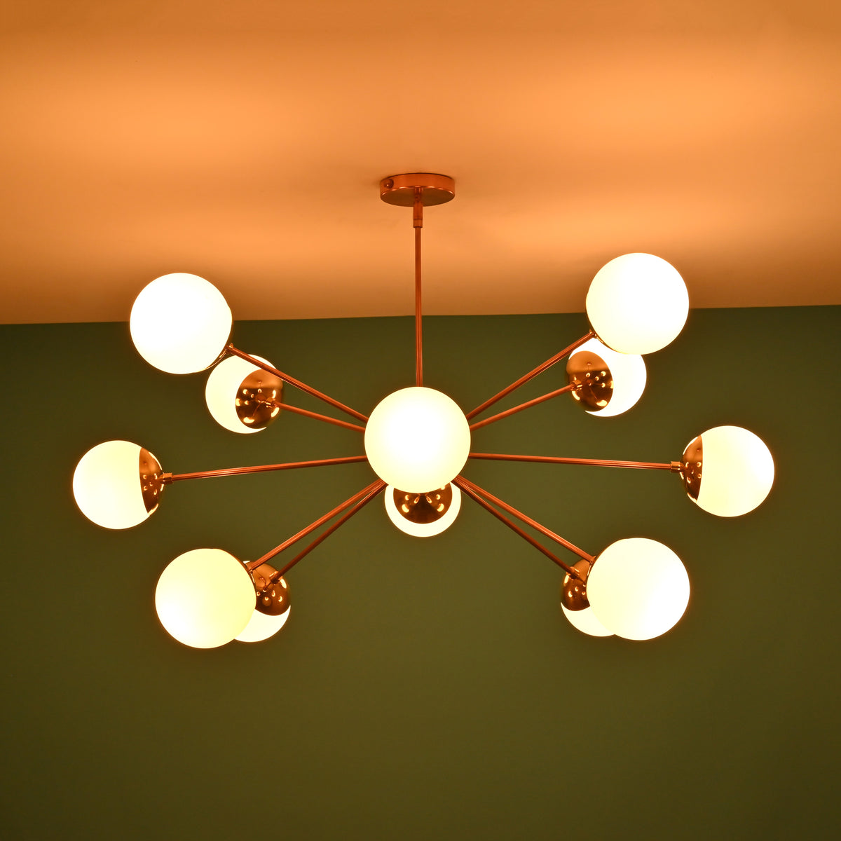 Handmade 12 opal glass brass chandelier producing soft ambient glow with mid century modern aesthetic
