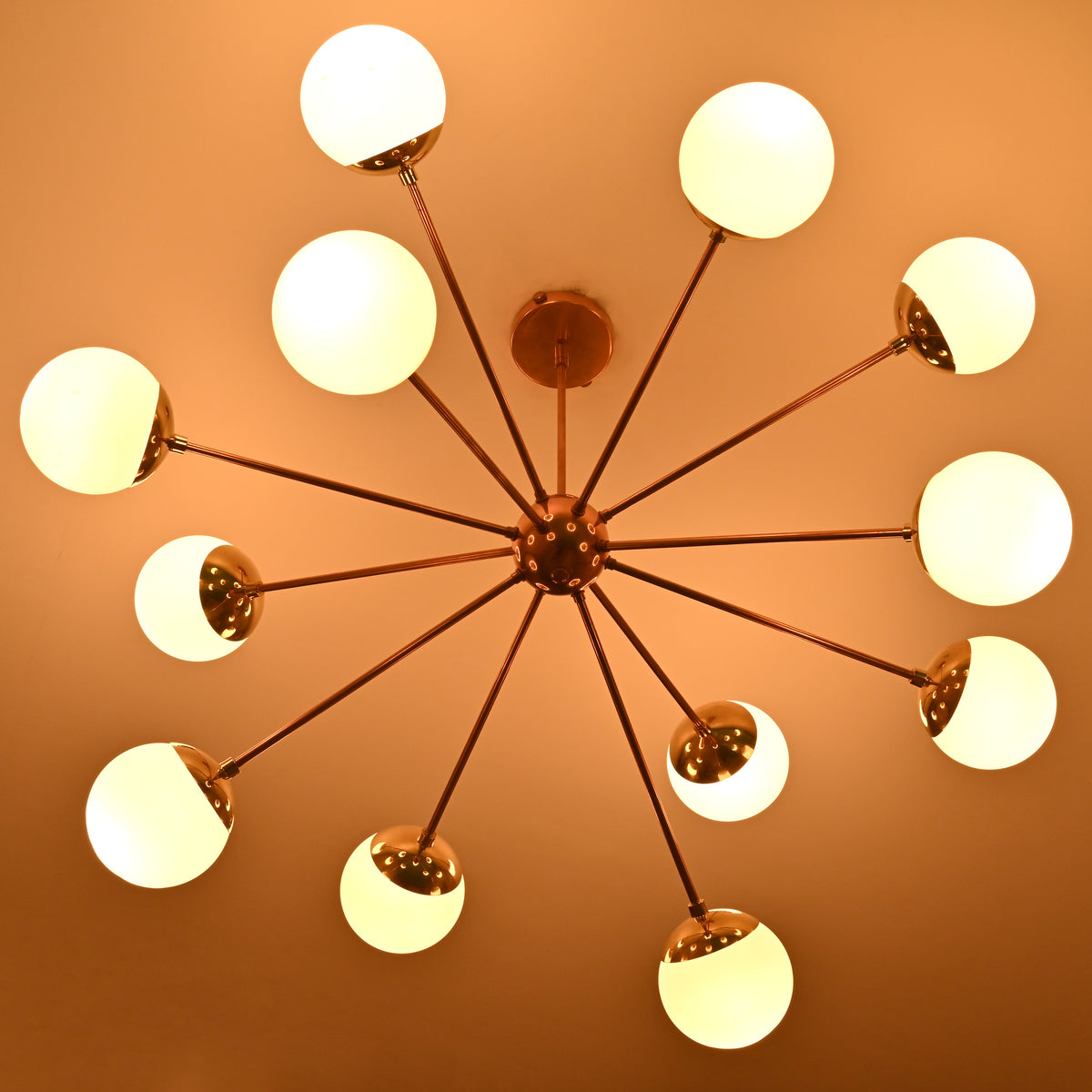 Mid century modern 12 opal glass chandelier in solid brass emitting soft warm ambient lighting