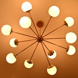 Mid century modern 12 opal glass chandelier in solid brass emitting soft warm ambient lighting