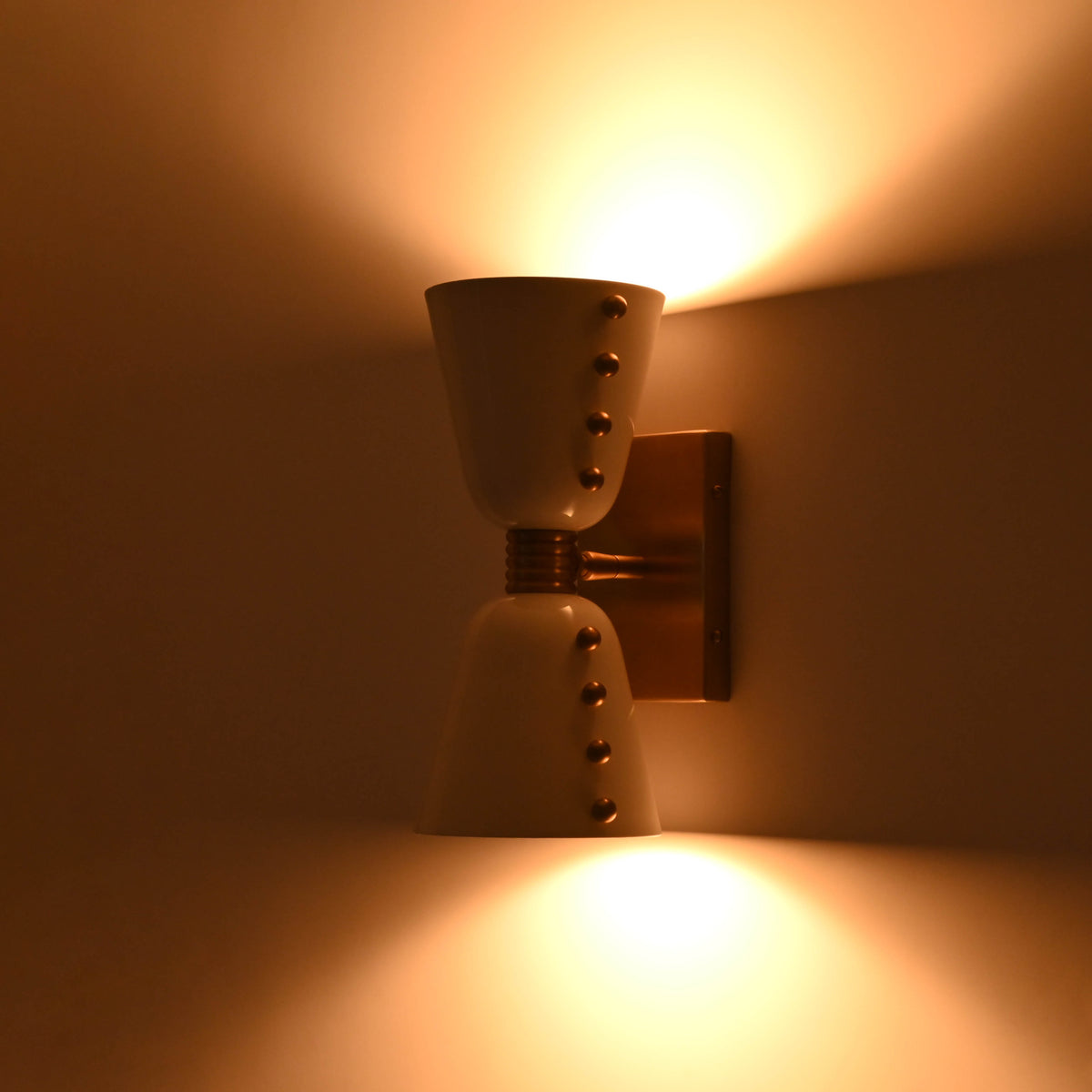 Two-light wall sconce creating warm ambient glow above and below for modern interior walls