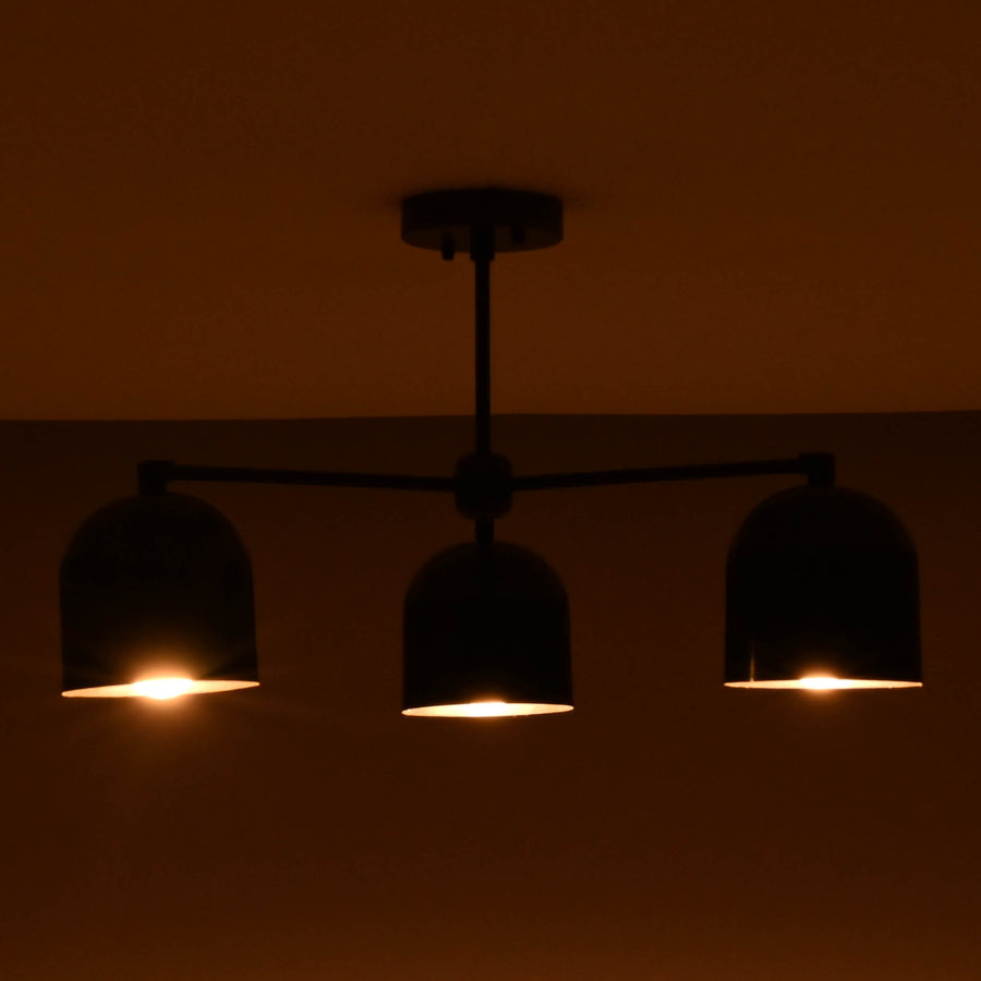 Front view of a 3 light brass bowl shade chandelier with black finish and warm interior glow.