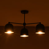 3 light brass bowl chandelier illuminated with warm ambient lighting in a dark interior setting.