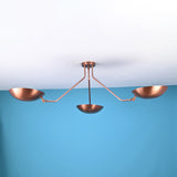 Modern 3 light brass flush mount ceiling light with bowl shaped shades and clean minimalist industrial arms