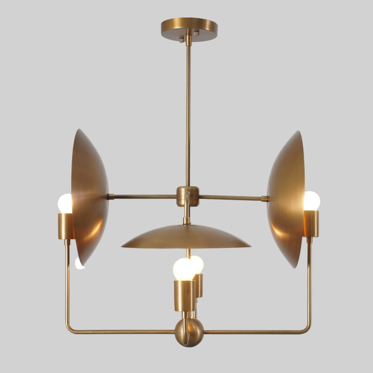 Modern brass chandelier with circular reflector discs and three exposed bulbs – handmade artistic lighting design by Brass Leaf Studio