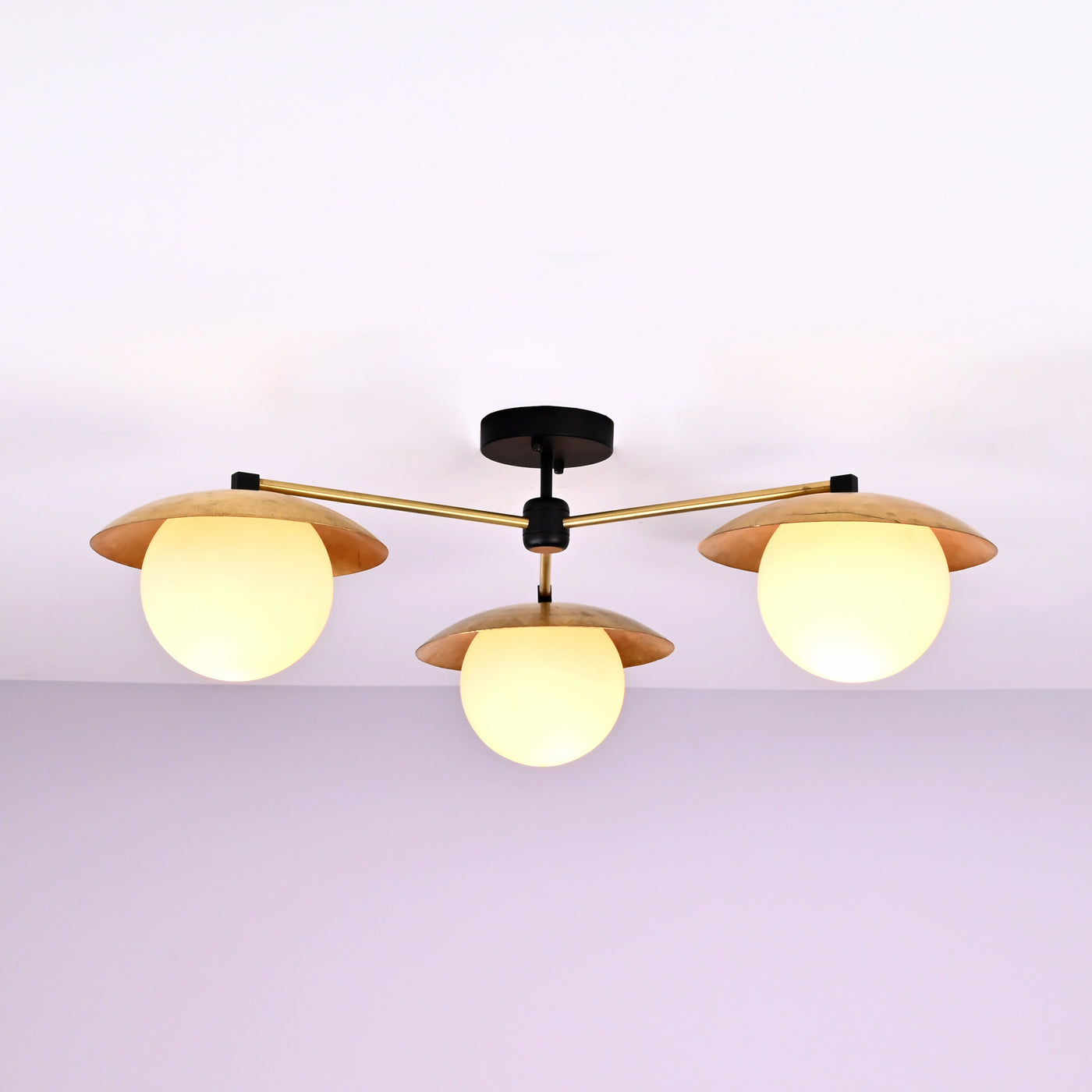 Front view of 3 light brass disc flush mount ceiling light with opal glass globes and modern industrial design.
