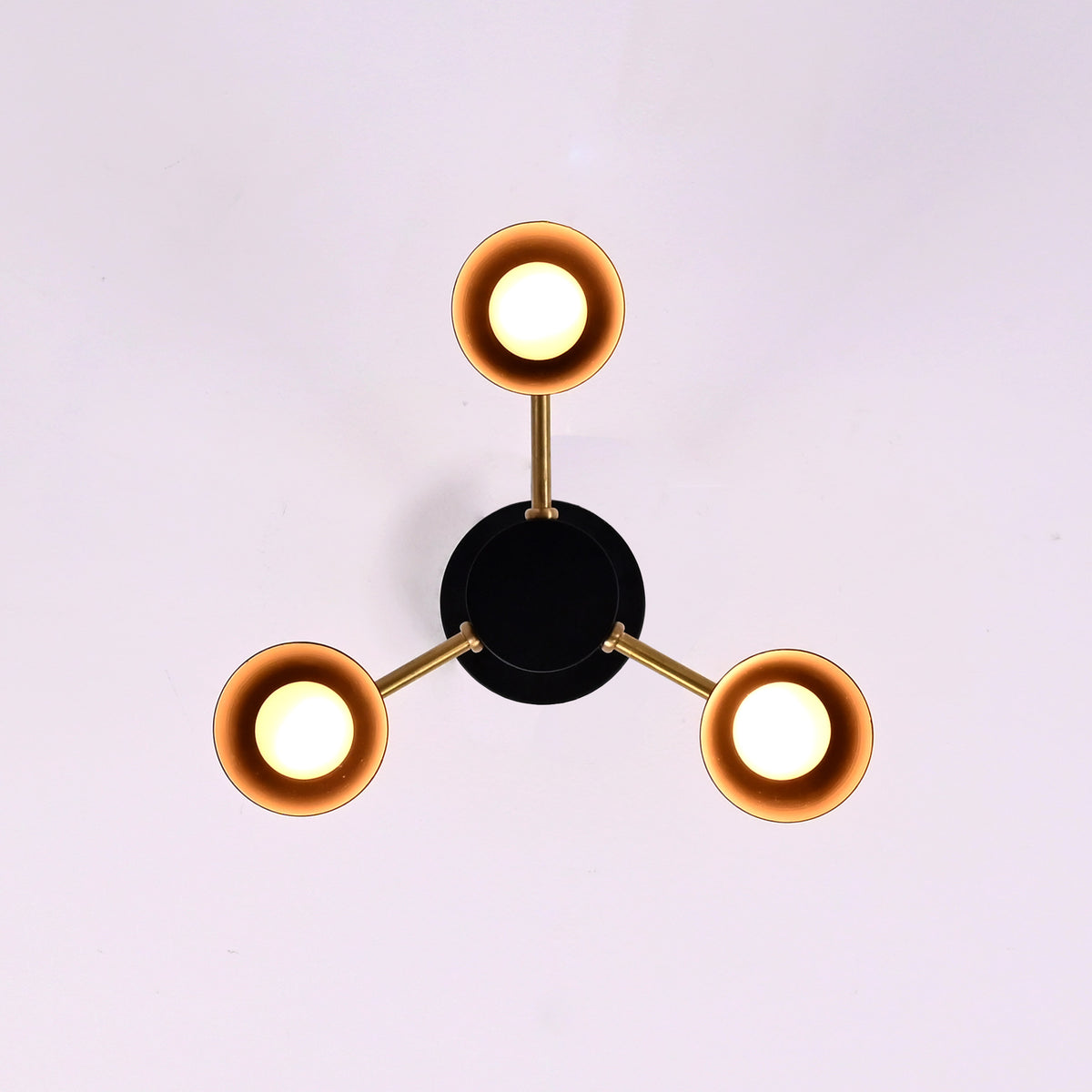 Top view of 3 light brass and black flush mount chandelier with cone shaped metal shades