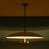 Wide night view of 3 light disc style brass chandelier with indirect lighting and modern elegance