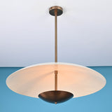 3 light disc style brass chandelier illuminated with warm ambient indirect lighting