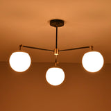 Bottom view of a 3 light opal glass globe chandelier highlighting balanced arms and glowing spheres.