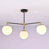Front view of a 3 light opal glass globe brass chandelier with black arms and brushed brass accents.