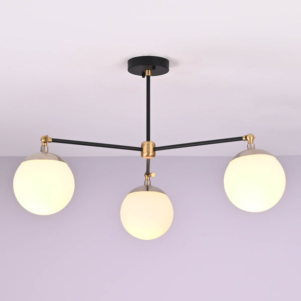 Front view of a 3 light opal glass globe brass chandelier with black arms and brushed brass accents.
