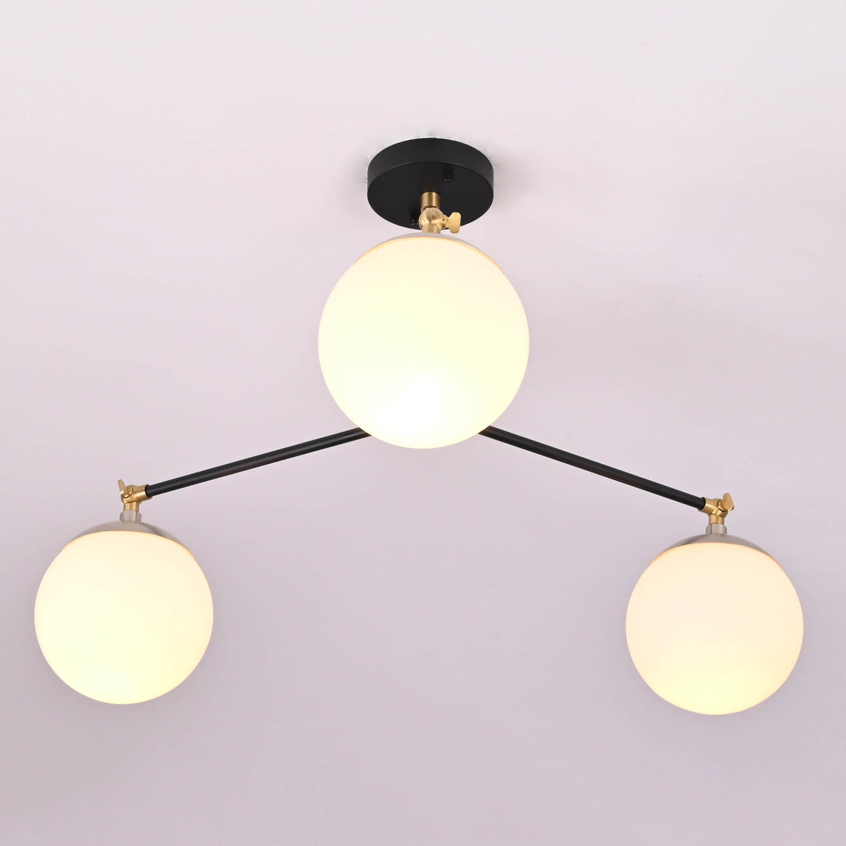 Symmetrical layout of a handcrafted 3 light opal glass globe chandelier with minimalist brass detailing.
