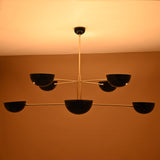 8-Light Brass Pendant Illuminated – Warm Ambient Glow with Black Bowl Shades