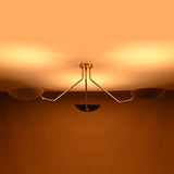 Ambient lighting view of brass 3-light ceiling fixture with bowl-shaped reflectors