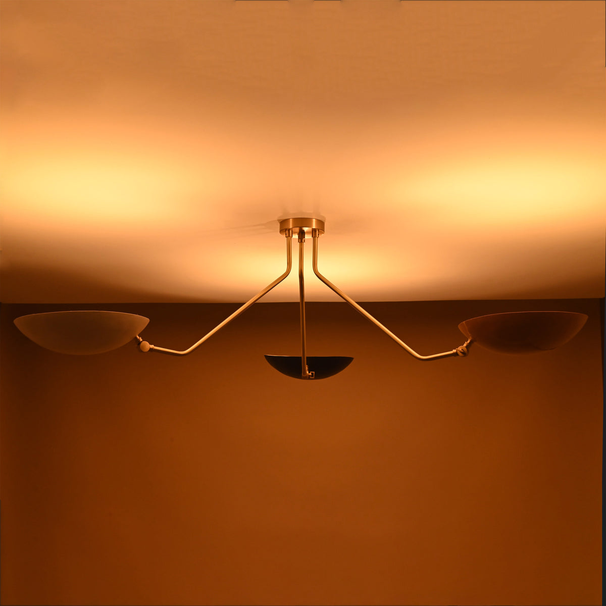 Contemporary brass three-arm ceiling light with reflective bowl shades — warm ambient glow