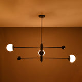 Modern matte black orb chandelier glowing with warm ambient light – centered view
