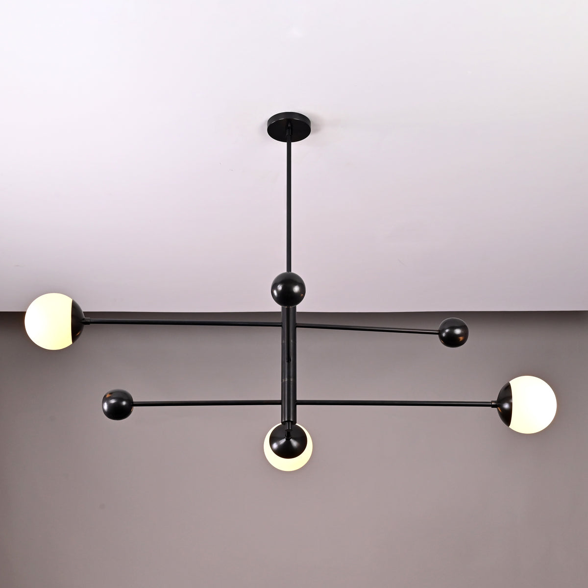 Contemporary 3-light black brass chandelier with spherical opal glass globes – side angle