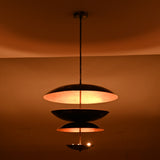 Tall three-tier pendant chandelier with black exterior and copper inner finish