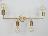 Symmetrical four-light brass wall sconce with exposed bulbs