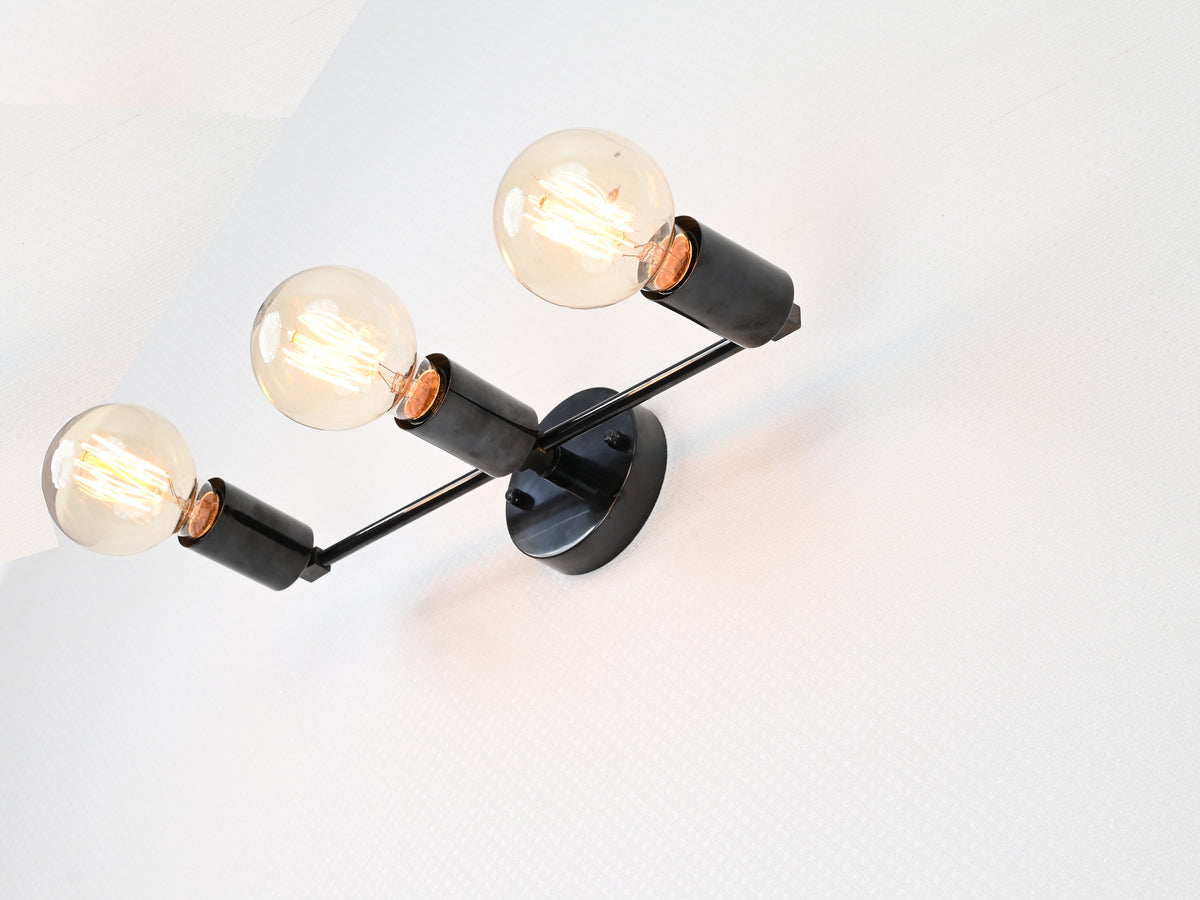 Three-light wall-mounted brass fixture for hallway or vanity