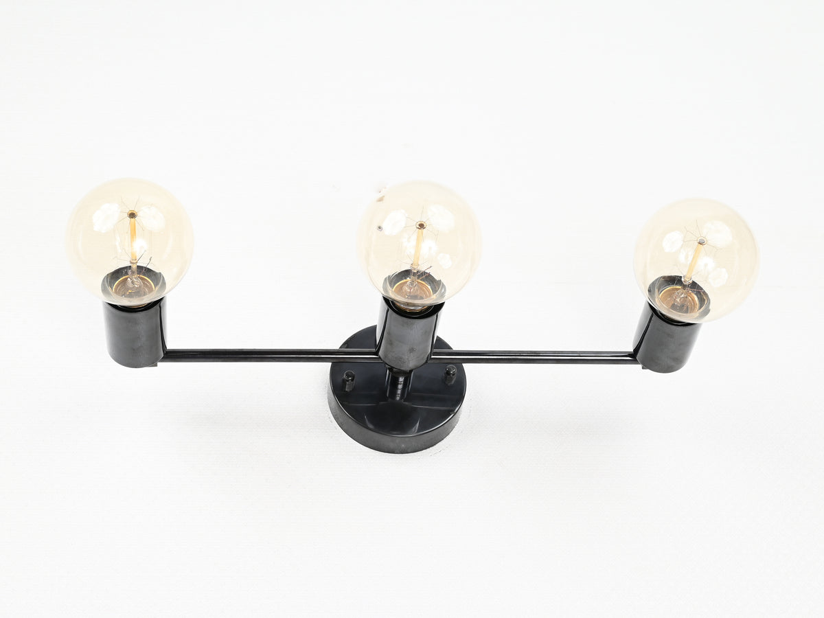 Modern brass vanity wall light with three exposed bulbs