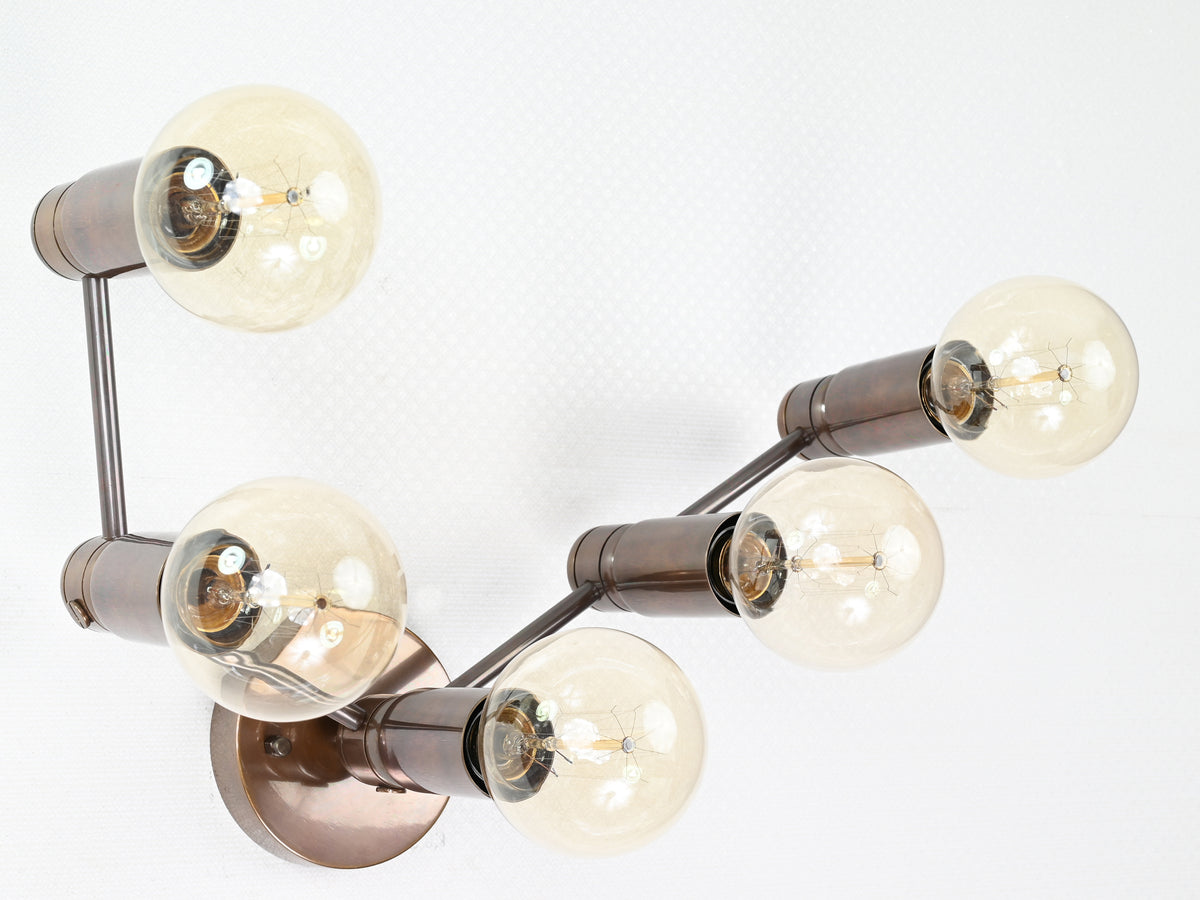 Five-light linear brass wall sconce with exposed bulbs