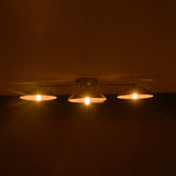 Three lit light bulbs hanging from a ceiling in a dark setting