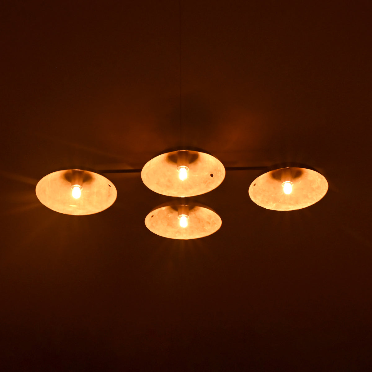 Four circular lights emitting a warm glow against a dark background