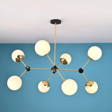 Overhead view of a brass and black modern chandelier with eight frosted glass globe shades in a geometric arrangement