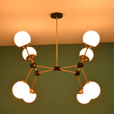 Black and brass eight-light chandelier with glowing white glass globes, photographed in a dim-lit setting.