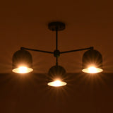 Modern chandelier with three illuminated lights against a dark background