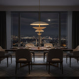 A modern multi-tier pendant light fixture with fluted, scalloped shades in warm cream and beige tones, accented by gold-toned metal rods and inner linings, shown against a solid white background.