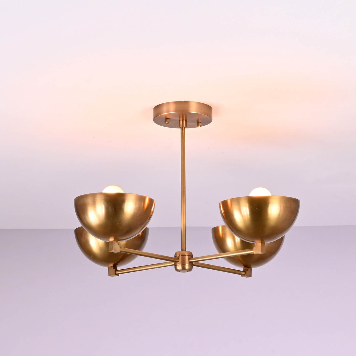 Side profile of a brushed brass 4 bowl chandelier displaying its clean horizontal arm structure and softly curved brass shades.