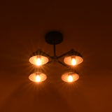 Evening view of 4 bulb modern brass and black flush mount chandelier with dome shades