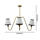 4-light brass chandelier with cream fabric shades and black trim shown illuminated with warm ambient glow