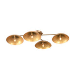 Overhead angled view of a 4-light brushed brass flush mount chandelier with bowl-shaped shades, lit with warm bulbs.