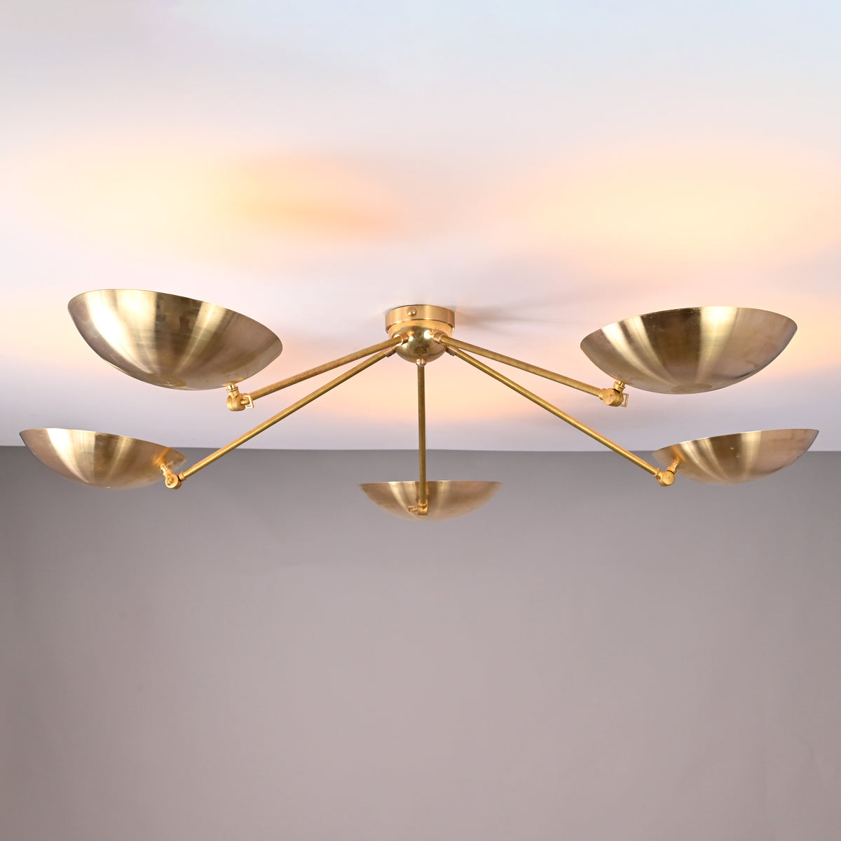 Front view of 5-light solid brass flushmount chandelier with wide bowl shades and warm indirect uplighting.