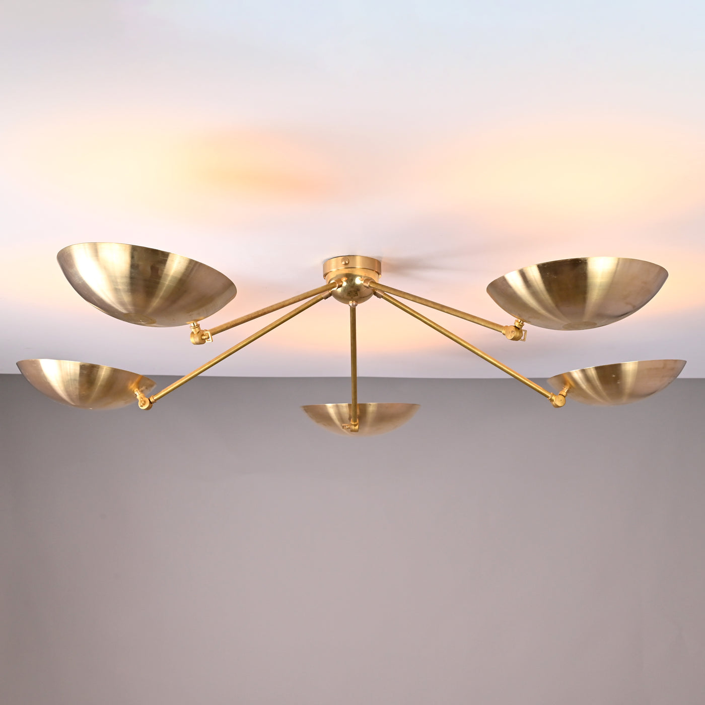 Front view of 5-light solid brass flushmount chandelier with wide bowl shades and warm indirect uplighting.