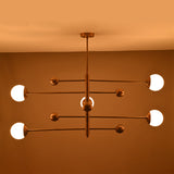 Evening illumination from a 5-light brass chandelier with glowing opal glass globes producing soft, warm ambient light.
