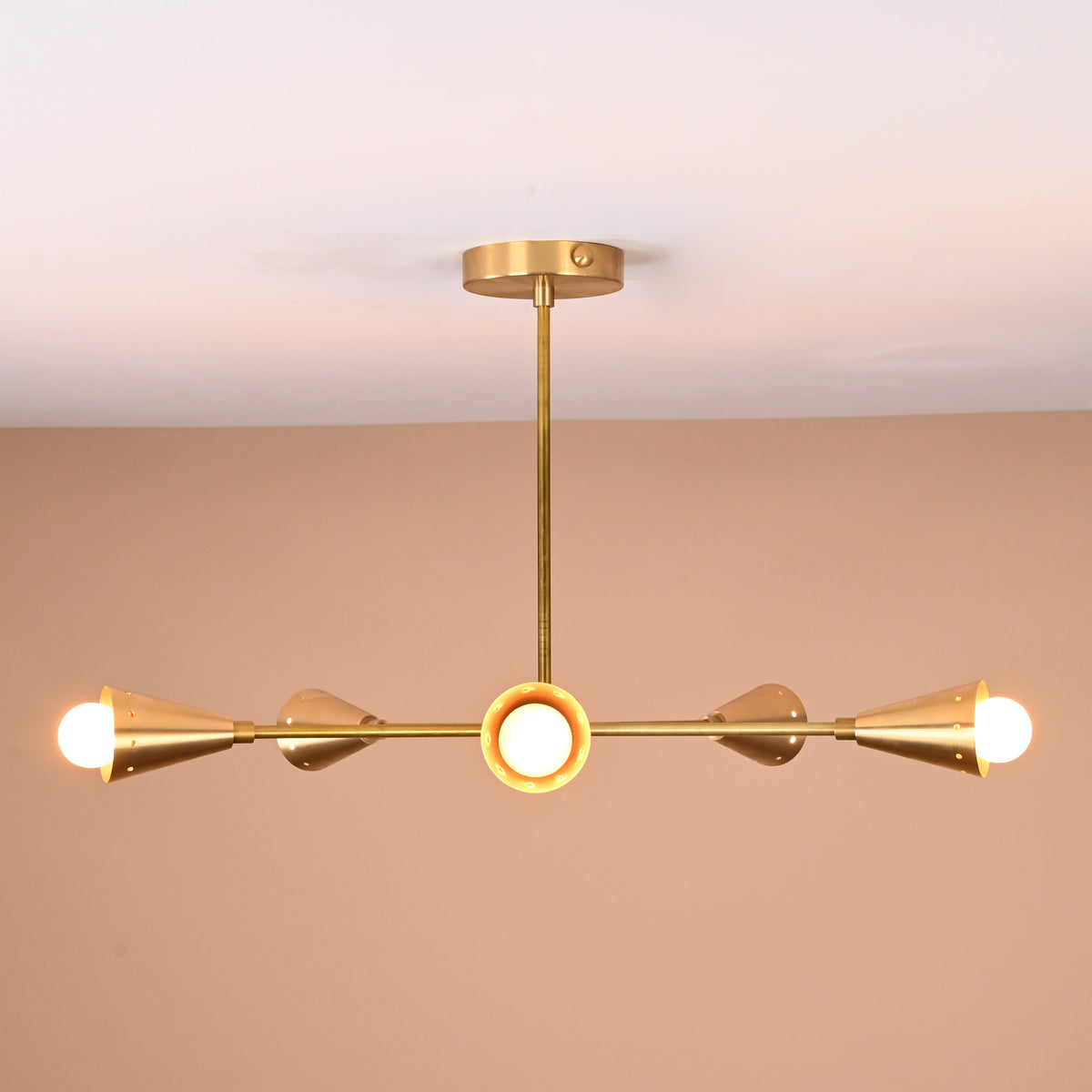 Side view of 5-light brass cone chandelier featuring sleek rods and precision-polished cones in satin brass finish, perfect for living or dining rooms.