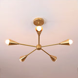 Overhead top view of 5-light brass ceiling fixture displaying perfect symmetry and modern geometric form in brushed brass with soft ambient glow.