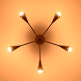 Illuminated 5-light brass cone chandelier casting warm ambient light with mid-century style elegance, ideal for refined home and commercial interiors.