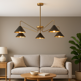 Interior mockup showing 5-light brass cone chandelier installed above a modern living room sofa, illuminating the space warmly.