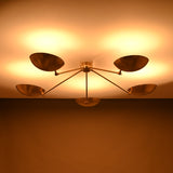 Soft warm illumination from a handcrafted 5-light brass flushmount light with wide reflective brass shades.