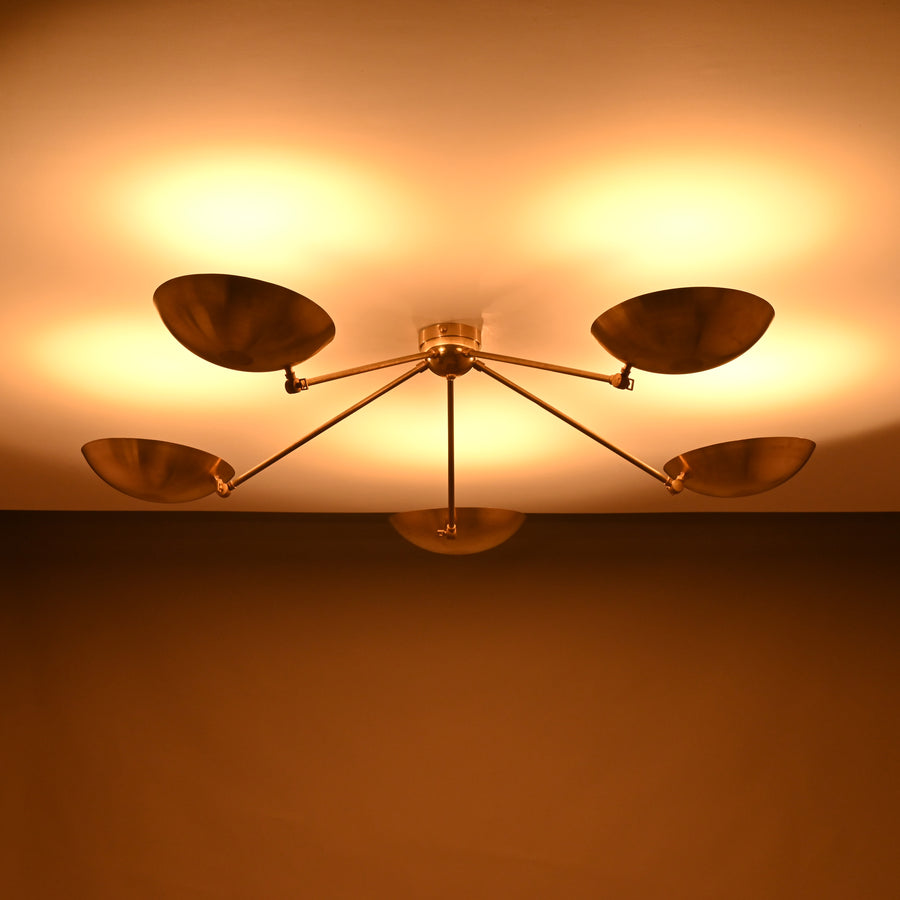 Front view of 5-light solid brass flushmount chandelier with wide bowl shades and warm indirect uplighting.