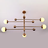 Modern 5-light brass chandelier with opal glass globes arranged on linear brass arms for balanced contemporary lighting.
